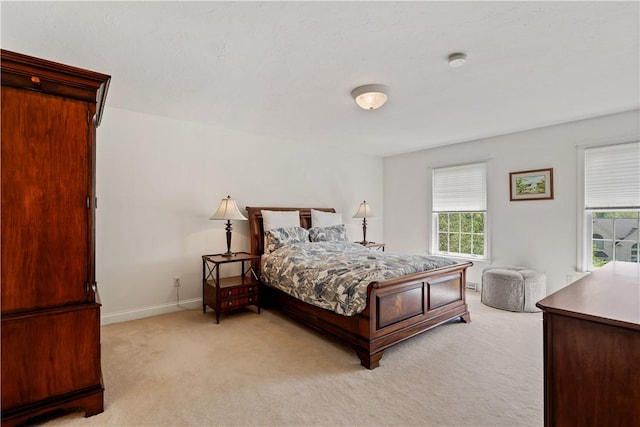 bedroom with light carpet, multiple windows, and baseboards