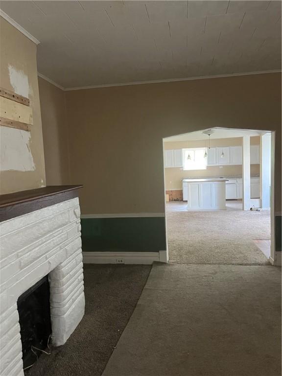 179 Washington St, Etna, PA 15223 - unfurnished living room featuring crown molding, carpet flooring, a stone fireplace, and baseboards