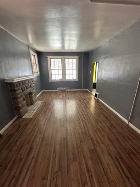 816 Franklin Ave, Aliquippa, PA 15001 - unfurnished living room featuring baseboards, a stone fireplace, wood finished floors, and arched walkways