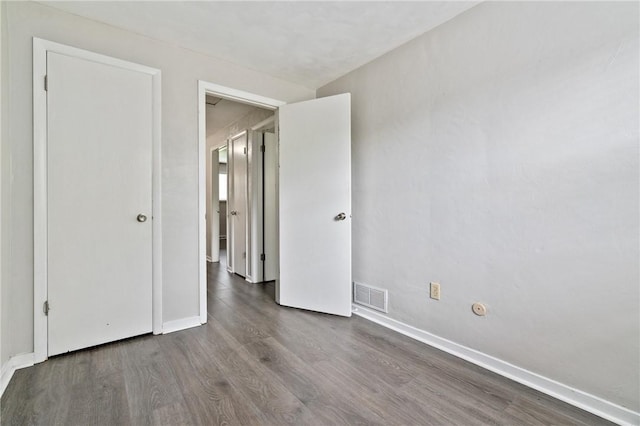 unfurnished bedroom with wood finished floors and baseboards