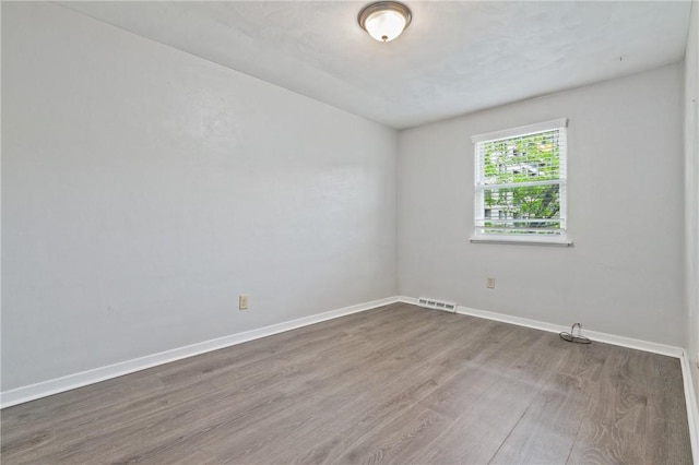 spare room with wood finished floors and baseboards