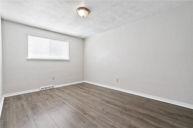 unfurnished room with wood finished floors and baseboards