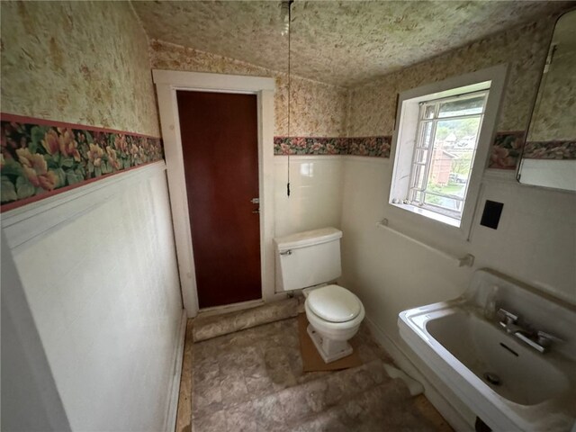 816 Main St, Brockway, PA 15824 - bathroom featuring a wainscoted wall, toilet, wallpapered walls, and a sink