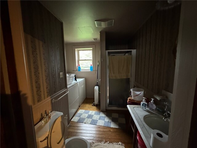 816 Main St, Brockway, PA 15824 - full bathroom featuring independent washer and dryer, a shower stall, a sink, hardwood / wood-style floors, and radiator heating unit