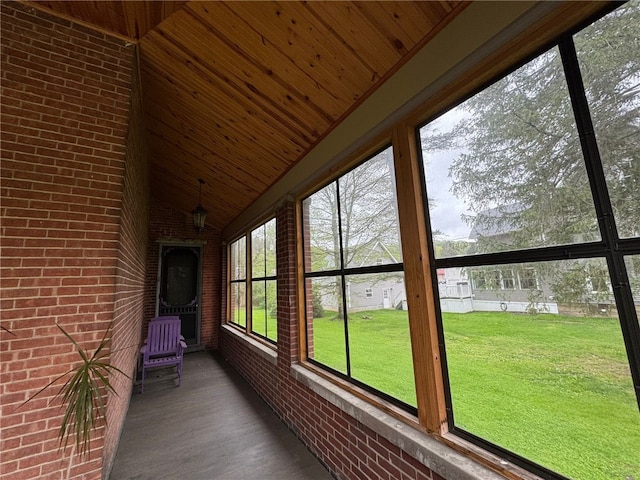unfurnished sunroom featuring vaulted ceiling