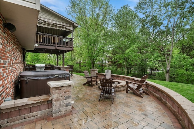 view of patio / terrace featuring a hot tub and an outdoor fire pit