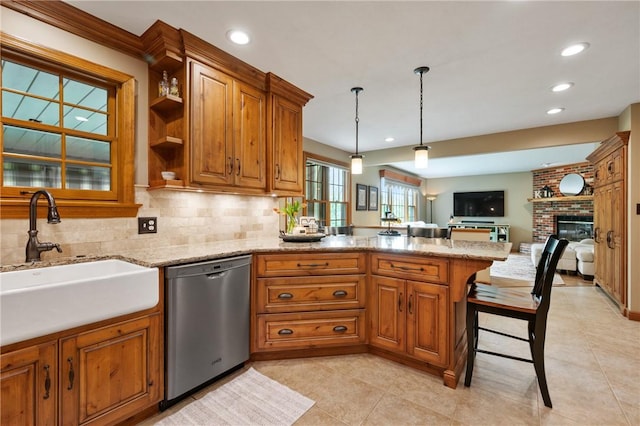kitchen with dishwasher, a sink, a peninsula, brown cabinets, and open floor plan