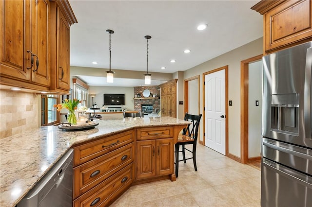 kitchen featuring stainless steel appliances, a peninsula, brown cabinets, tasteful backsplash, and recessed lighting