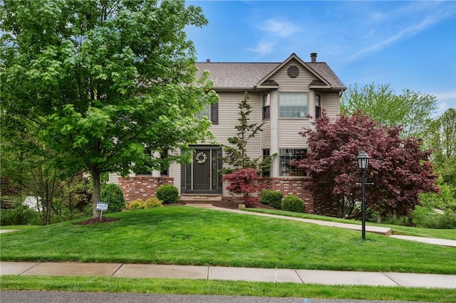view of front of home with a front lawn and brick siding