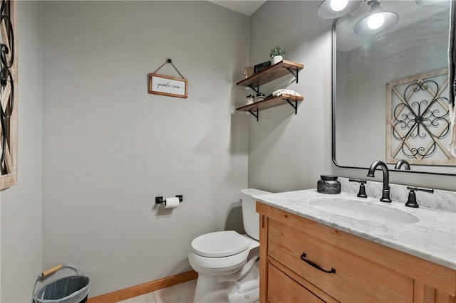 half bath with tile patterned floors, toilet, vanity, and baseboards