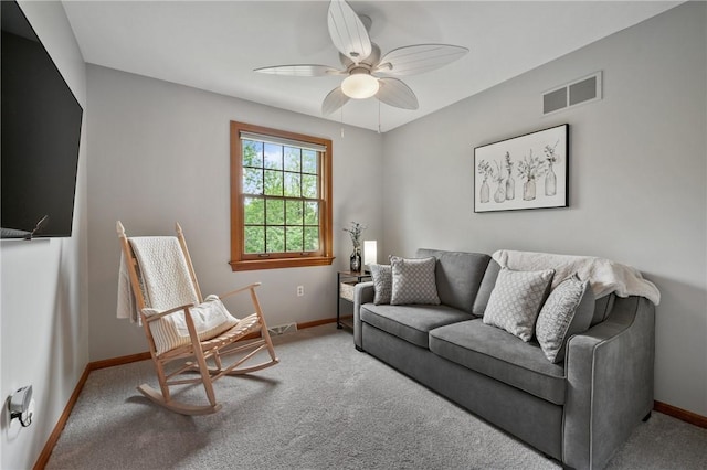 living area featuring baseboards, ceiling fan, and carpet
