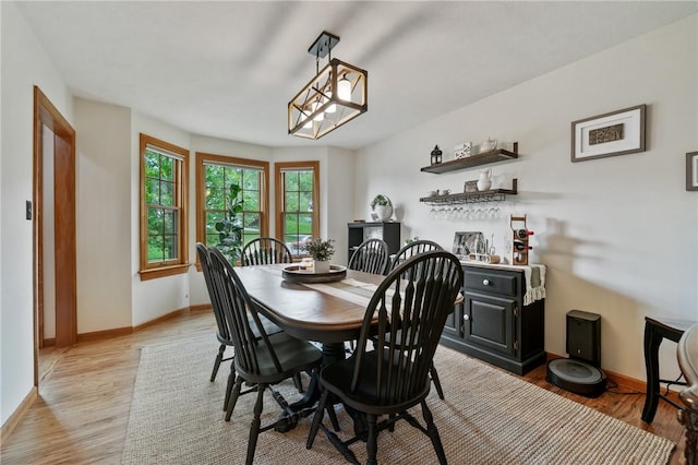 dining space featuring baseboards and light wood-style floors