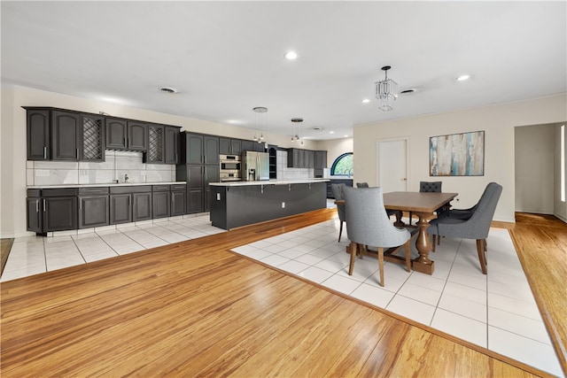 dining space with light wood-style floors, recessed lighting, a chandelier, and baseboards
