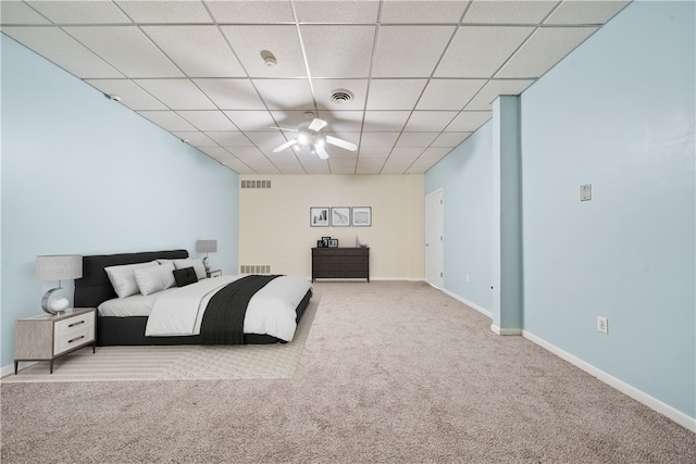 carpeted bedroom featuring a paneled ceiling and baseboards