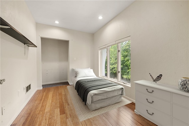 bedroom with light wood-type flooring, baseboards, and recessed lighting