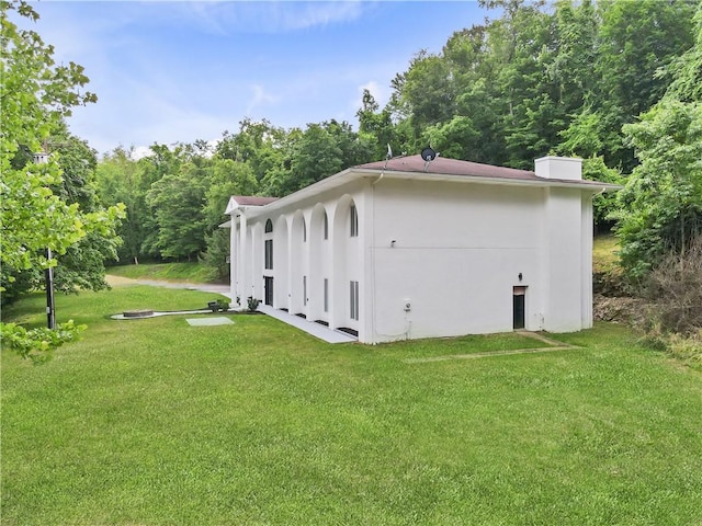view of property exterior with a lawn and stucco siding