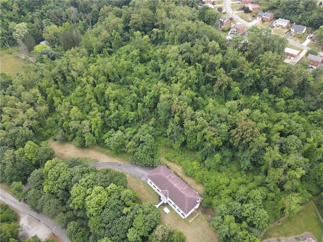 aerial view of property and surrounding area featuring a forest
