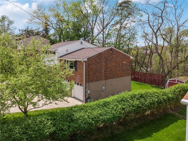 view of home's exterior with brick siding, a garage, and driveway