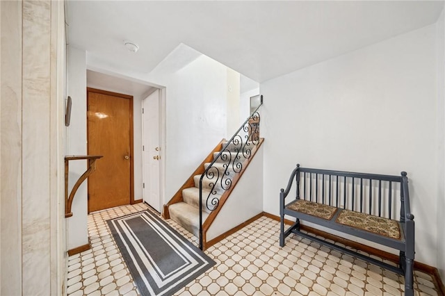 staircase featuring tile patterned floors and baseboards