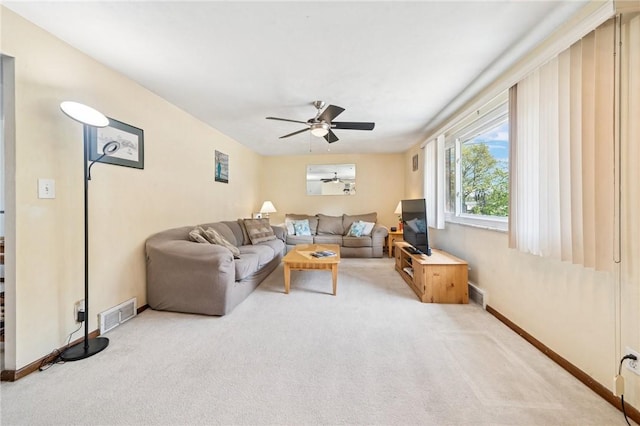 living room featuring light colored carpet, ceiling fan, and baseboards
