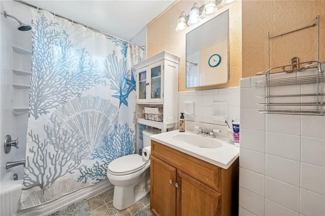 full bathroom with toilet, tile walls, vanity, and shower / tub combo