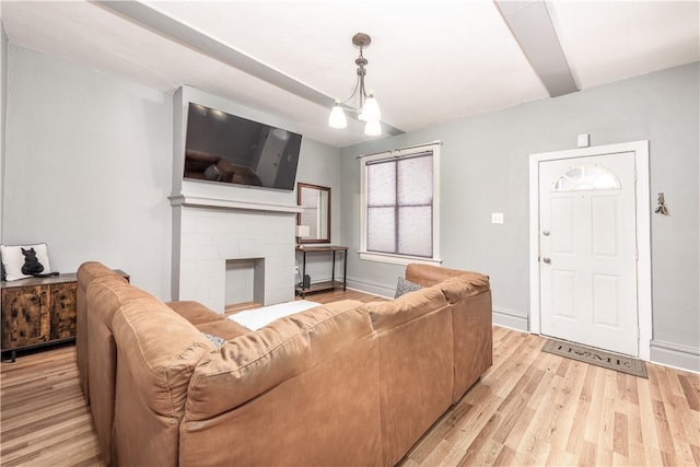 living area featuring light wood-type flooring, a fireplace, and baseboards