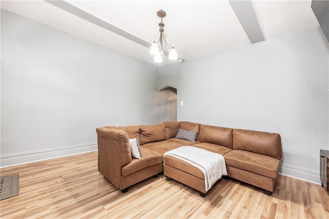 living area featuring light wood-style floors, baseboards, and a chandelier