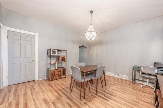 dining area with light wood-style floors, a chandelier, and an office area