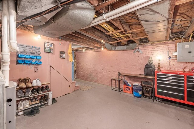 unfinished below grade area with a workshop area and electric panel