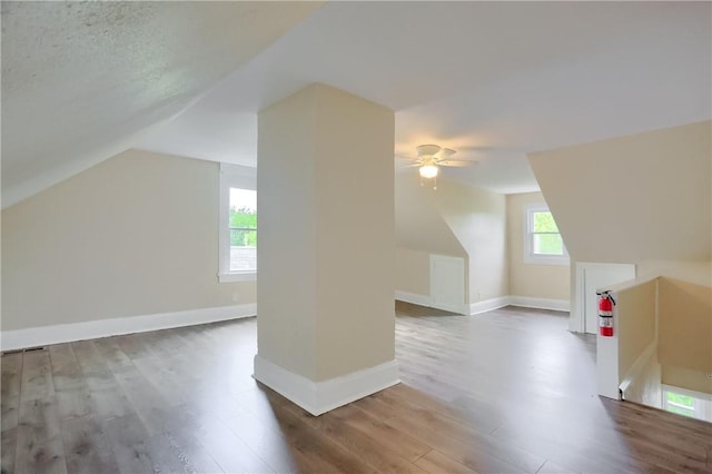 additional living space featuring ceiling fan, wood finished floors, vaulted ceiling, and baseboards