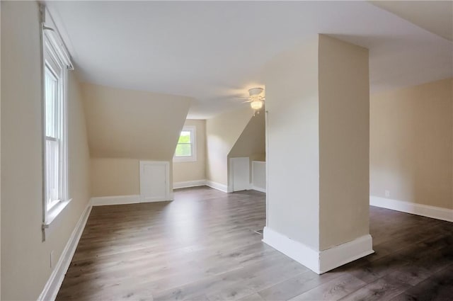 additional living space featuring a ceiling fan, wood finished floors, vaulted ceiling, and baseboards