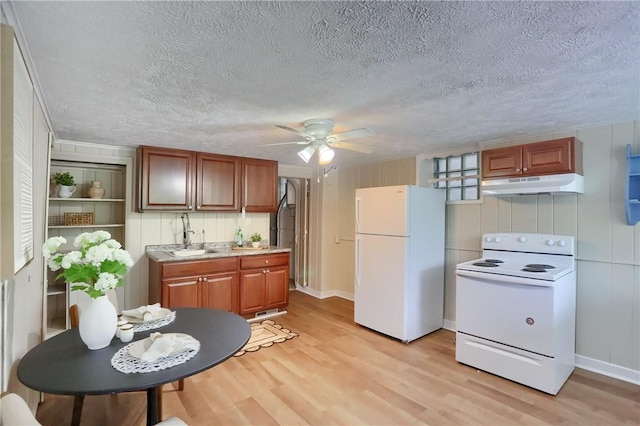 kitchen featuring white appliances, under cabinet range hood, light wood-type flooring, a ceiling fan, and a textured ceiling
