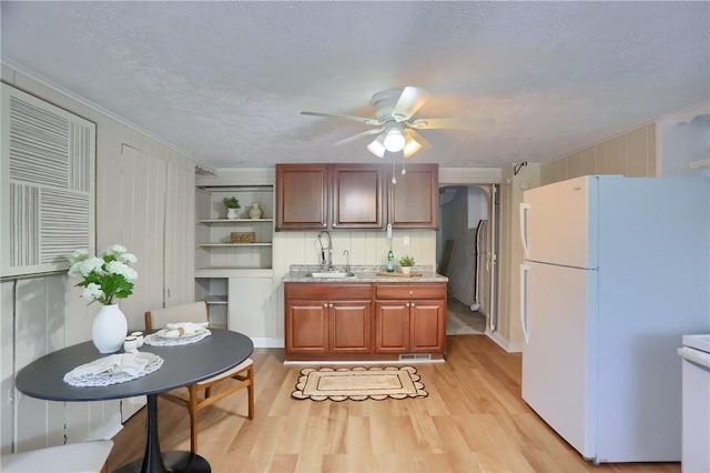 kitchen featuring freestanding refrigerator, light wood-style floors, a sink, open shelves, and ceiling fan