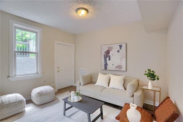 living area with light wood-type flooring and baseboards