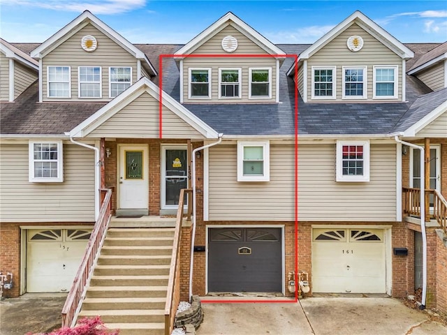 townhome / multi-family property with an attached garage, a shingled roof, and concrete driveway