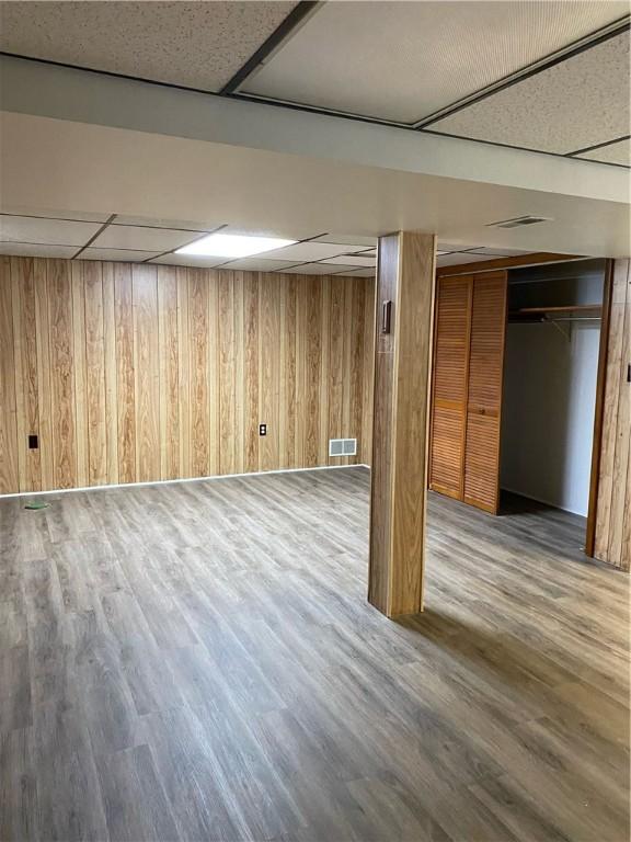 finished below grade area featuring wooden walls and wood finished floors
