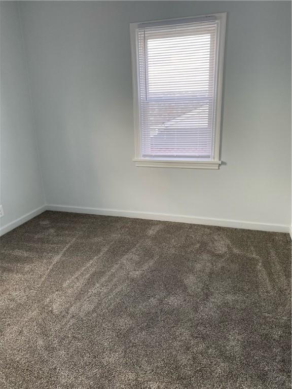 spare room with carpet and baseboards