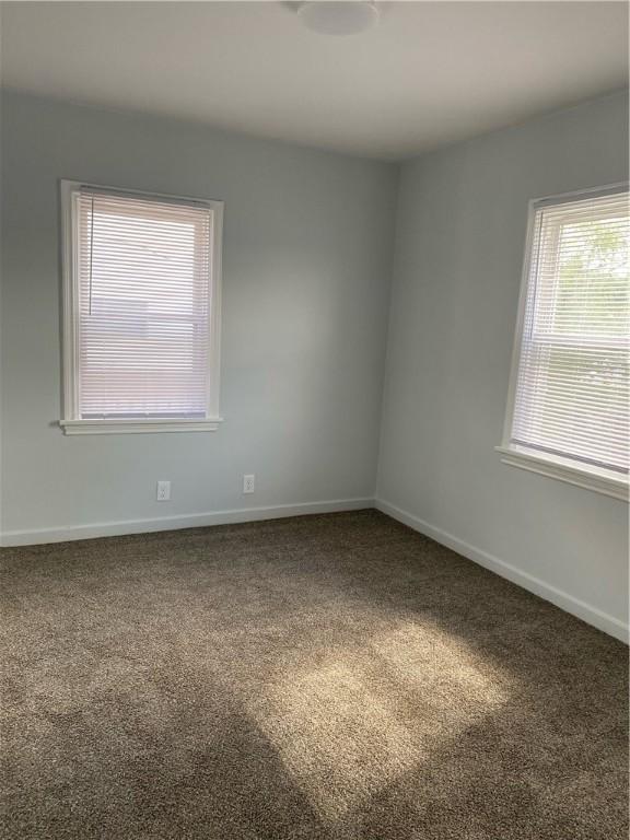 unfurnished room featuring carpet floors and baseboards