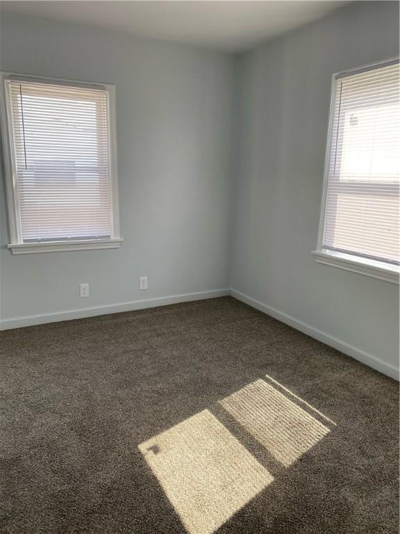 carpeted spare room featuring baseboards
