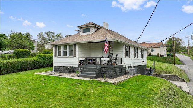 bungalow-style home featuring a chimney, a porch, a front yard, roof with shingles, and stairway