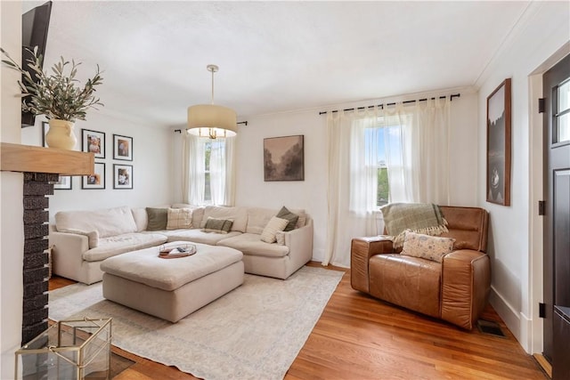 living area featuring light wood-style floors and ornamental molding