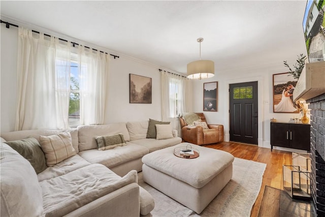 living room with plenty of natural light, wood finished floors, and a fireplace