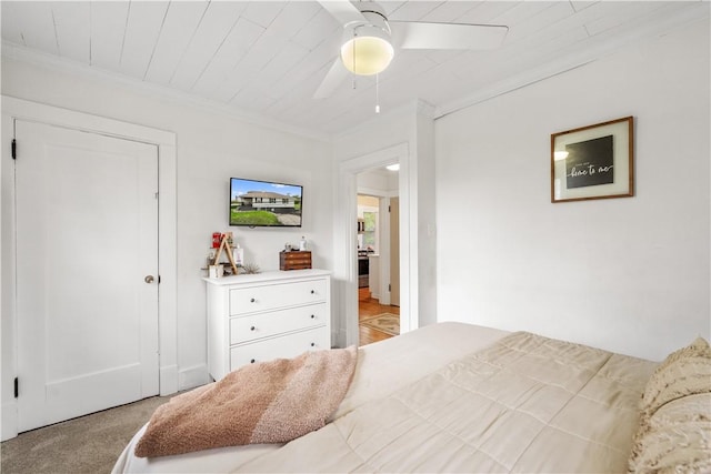 carpeted bedroom featuring ornamental molding and ceiling fan
