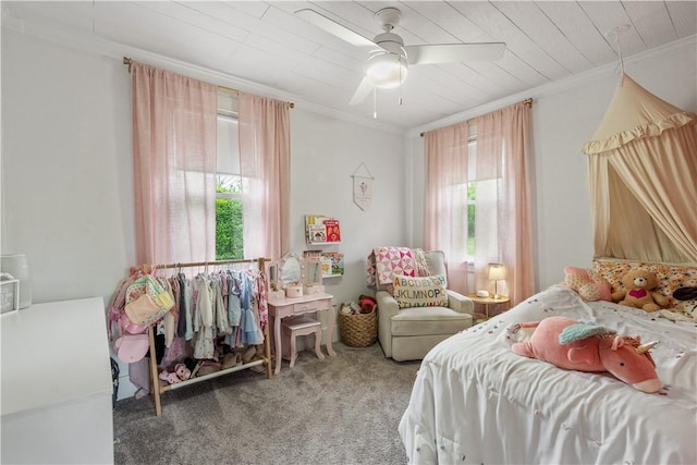 carpeted bedroom featuring multiple windows, ornamental molding, ceiling fan, and wood ceiling