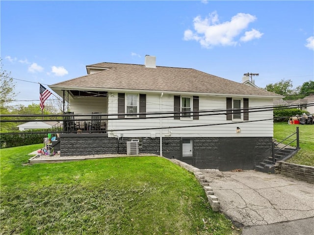 rear view of house with stairway, a lawn, roof with shingles, and a chimney