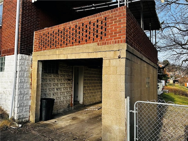 view of home's exterior featuring brick siding, a gate, and fence