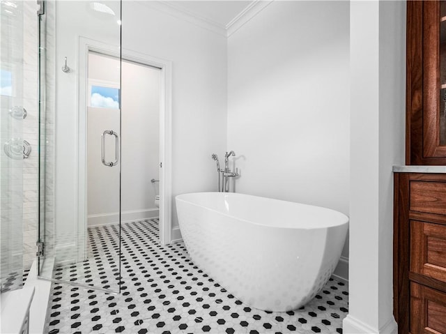 full bathroom featuring a stall shower, ornamental molding, a soaking tub, baseboards, and toilet