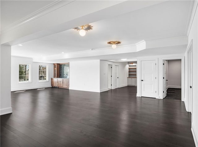 unfurnished living room featuring baseboards, dark wood-type flooring, ornamental molding, and recessed lighting