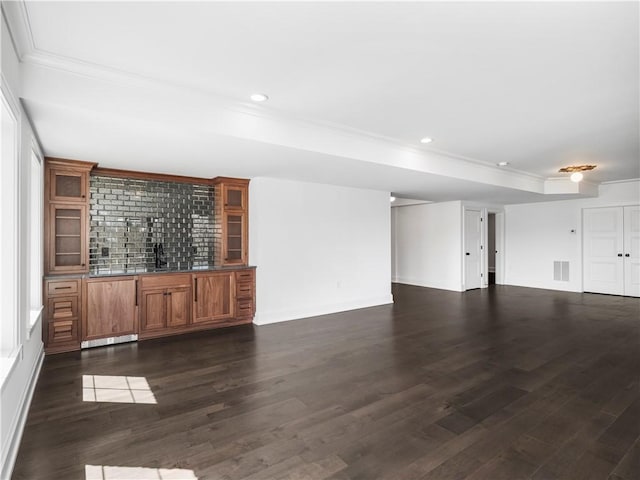 unfurnished living room with ornamental molding, dark wood-style flooring, recessed lighting, and bar