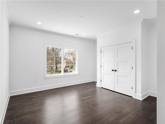 empty room with ornamental molding, baseboards, dark wood finished floors, and recessed lighting